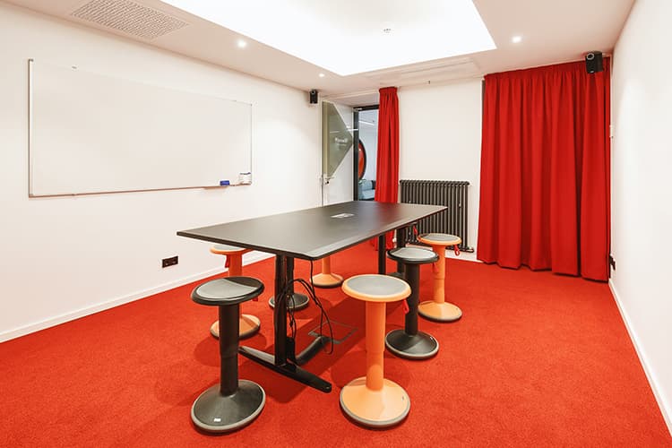 Vibrant 'Pioneer' meeting space with standing table at SPACE SHACK Coworking