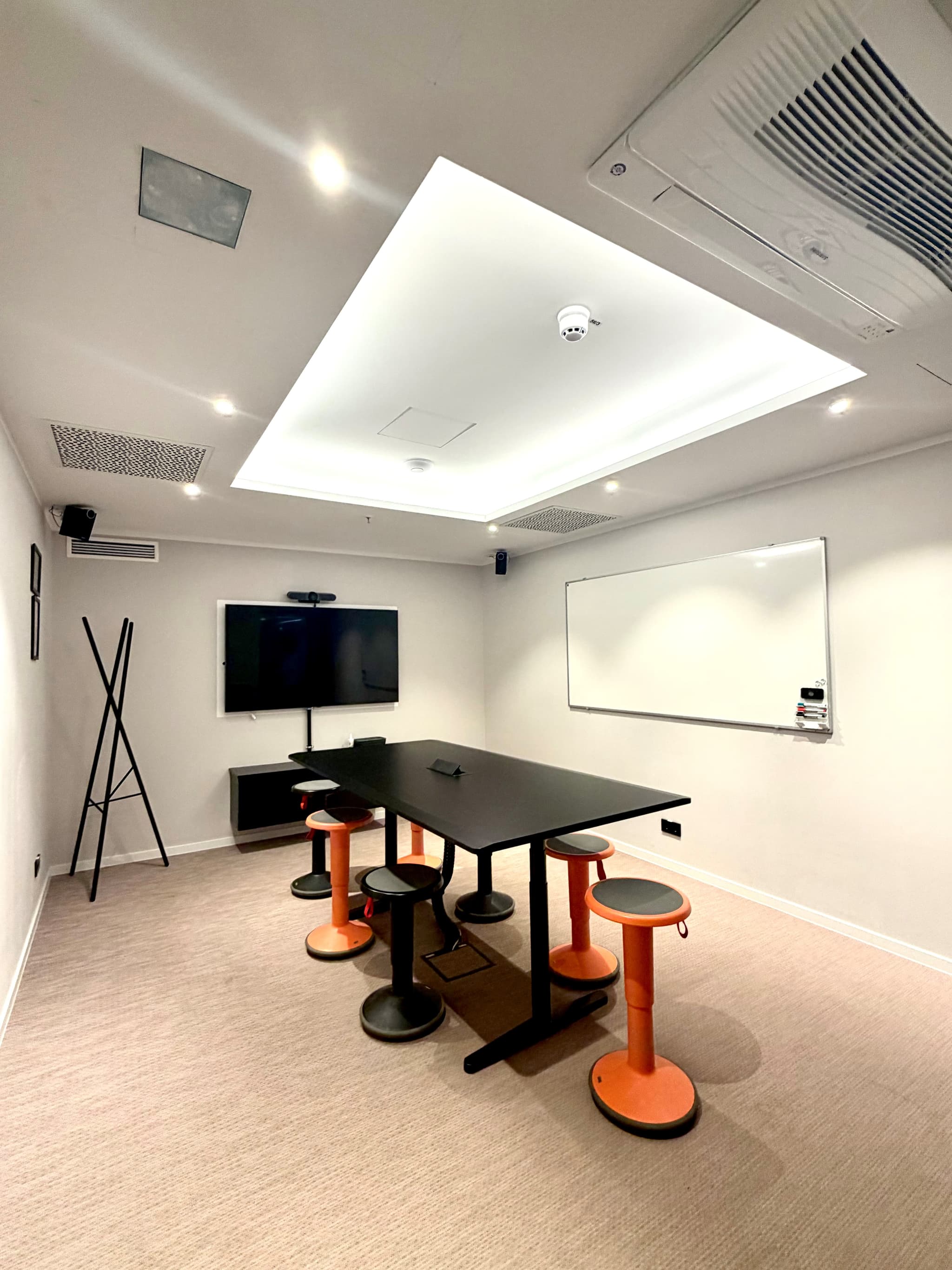 Vibrant 'Pioneer' meeting space with standing table at SPACE SHACK Coworking interior photo 3